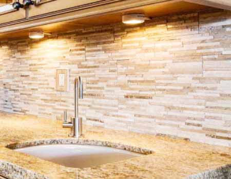 Mermer silim hizmeti için kullanılan görselde, Özmer Silim Cila firması tarafından parlatılmış modern bir granit mutfak tezgahı var.