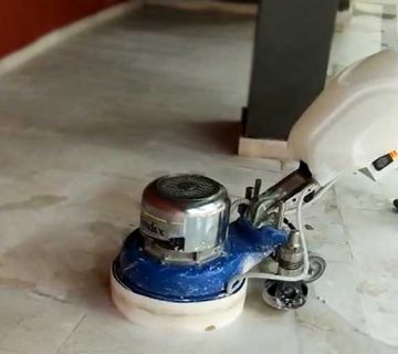 Mermer silim ustası yazısı için kullanılan öne çkarılmış görselde, profesyonel bir teknisyen yıpranmış doğal taş zemini parlatmak için silme makinesi ile cilalıyor.