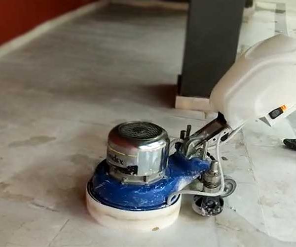 Mermer silim ustası yazısı için kullanılan öne çkarılmış görselde, profesyonel bir teknisyen yıpranmış doğal taş zemini parlatmak için silme makinesi ile cilalıyor.